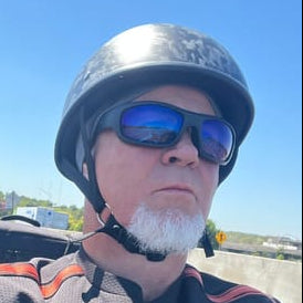 A man wearing a beanie-style helmet from beaniehelmets.com, sunglasses, and a t-shirt