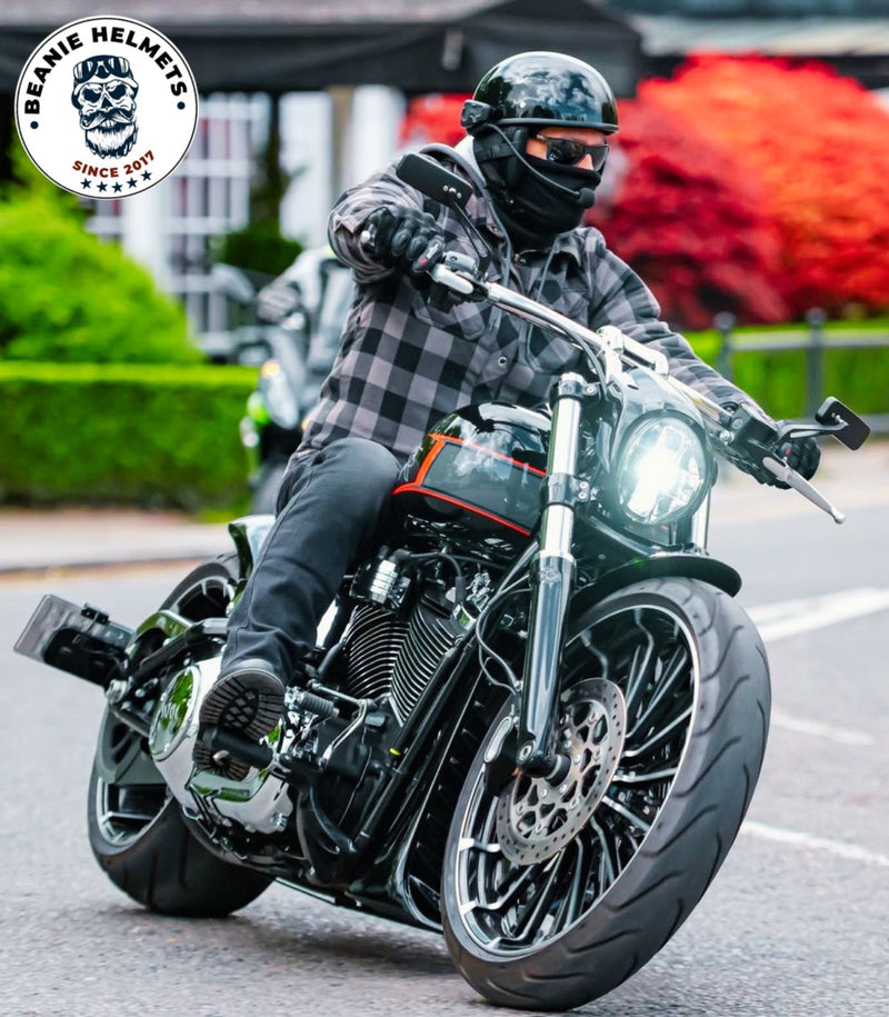A biker riding a motorcycle wearing a SOA-style Beanie Helmet with the beaniehelmets logo in the corner.